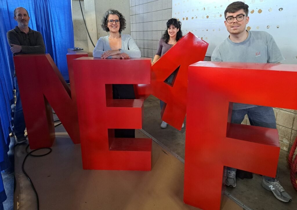 Lunático Astro team members with the NEAF letters at the 2025 show